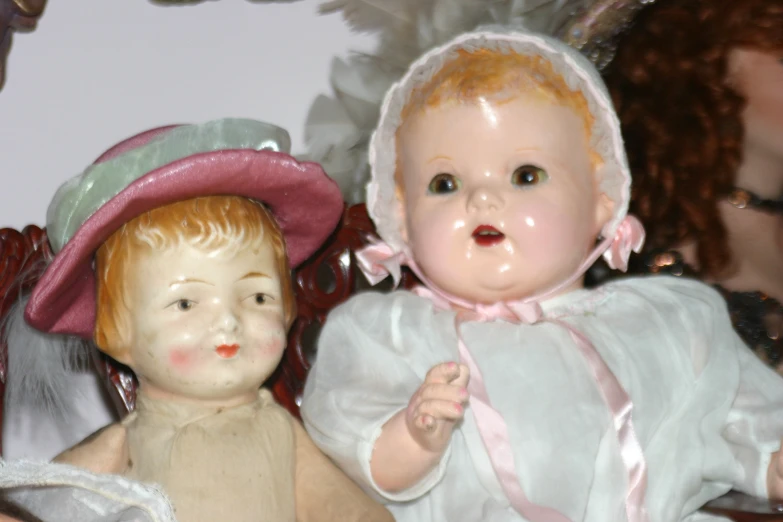 a baby doll that is standing next to an old lady doll