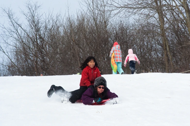 two s play in the snow with a sled