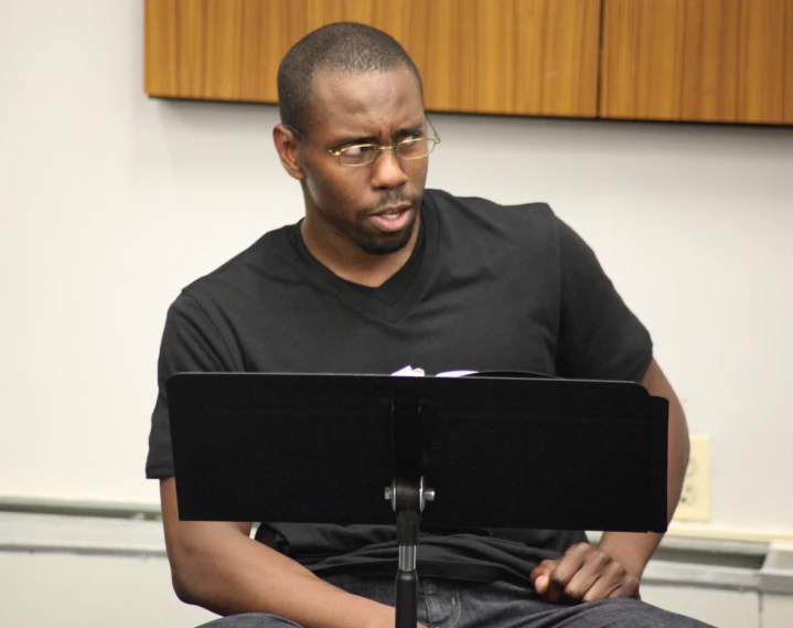 a man in a black shirt is playing a music keyboard