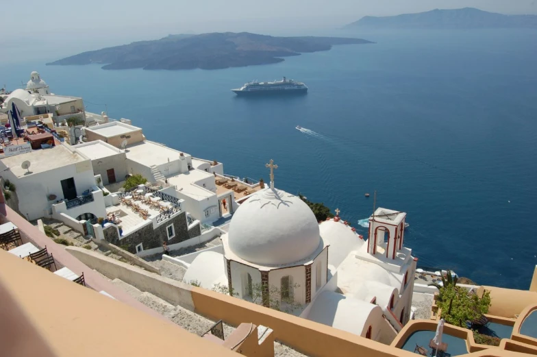 a ship sails through the ocean near a white building