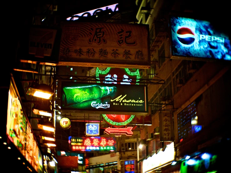 there are many lighted signs hanging in an oriental city