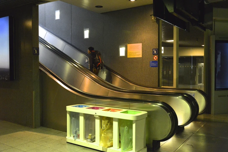 a empty bench sitting under an escalator at night