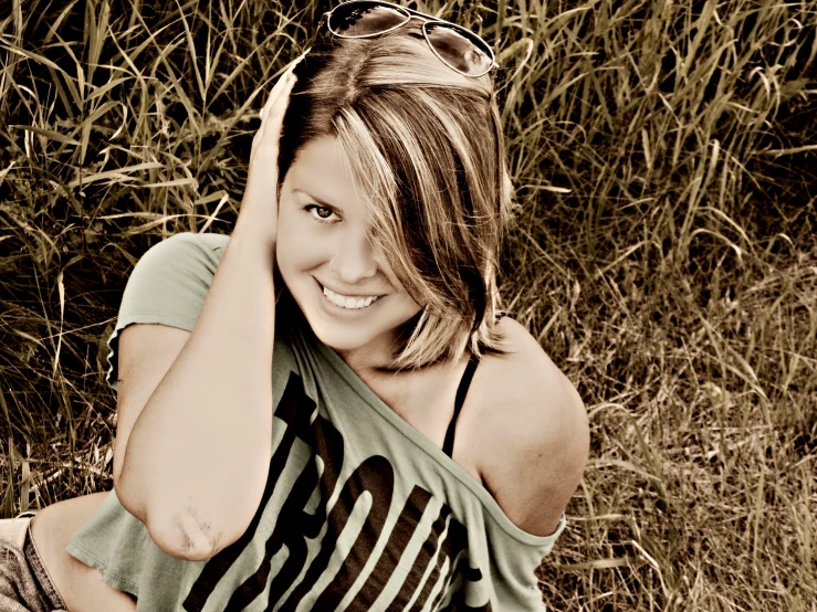 a  sitting in the grass, with her hair hanging back