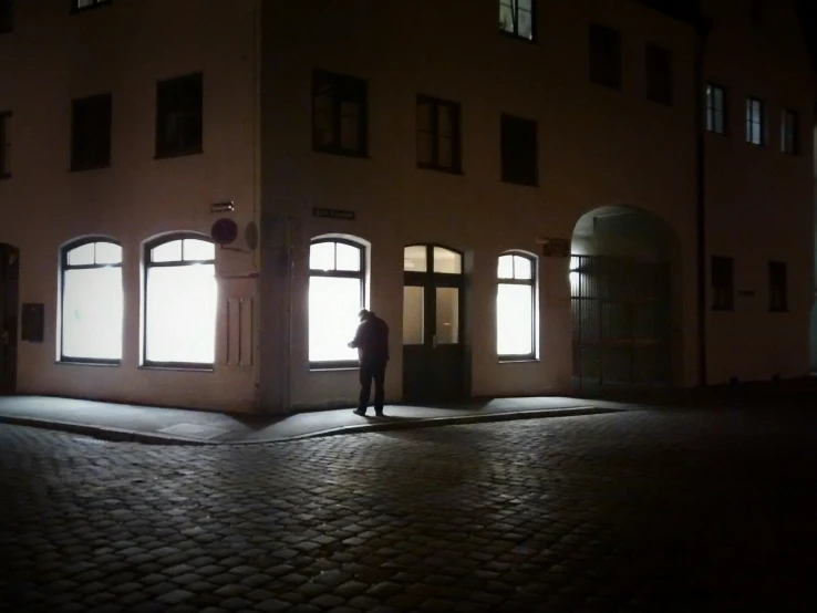 an empty street in front of a building at night