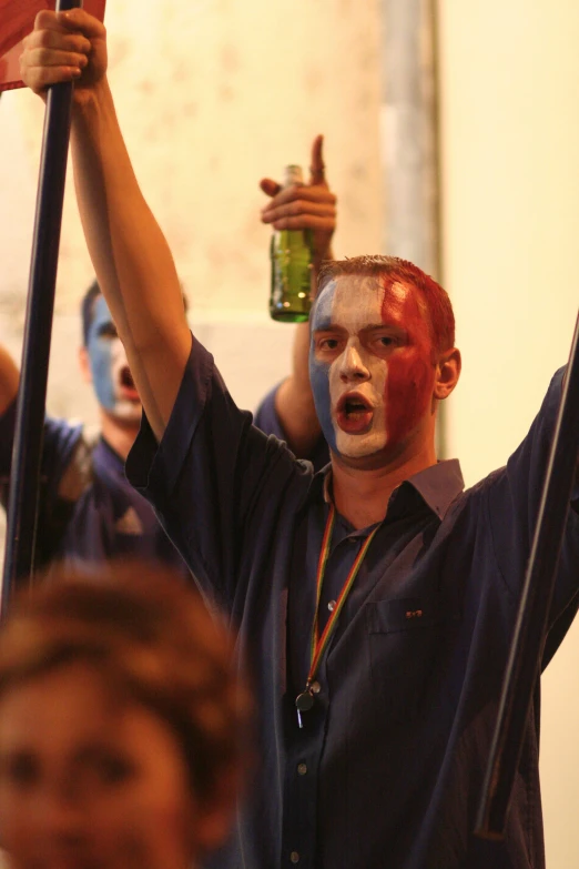 a man with face paint and beer standing