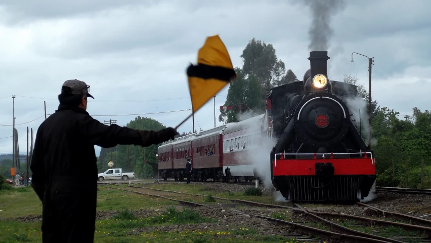 a man is standing in front of a steam engine