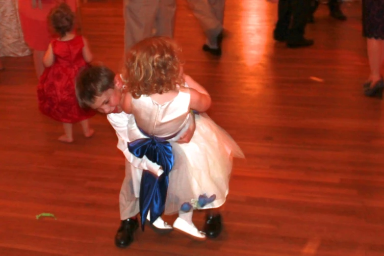 a little girl in a dress and another  on a dance floor