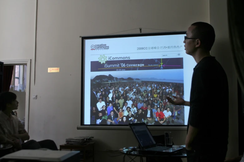 man giving presentation to audience in front of flat screen monitor