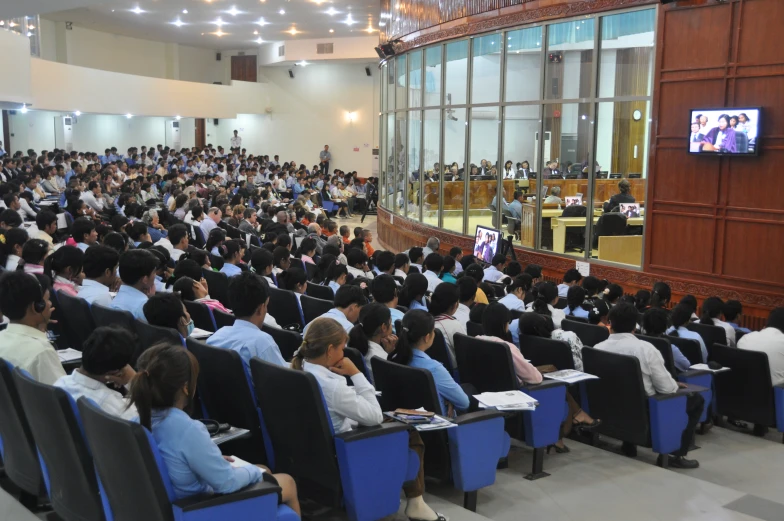 a group of people watching the speaker at a lecture hall