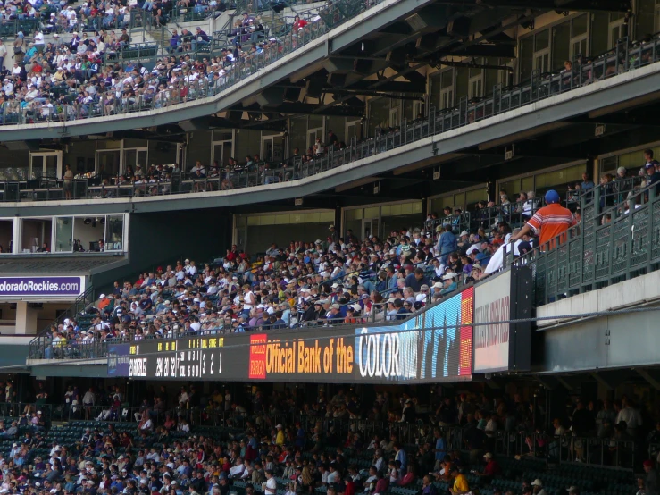 a full baseball stadium is shown with a big screen