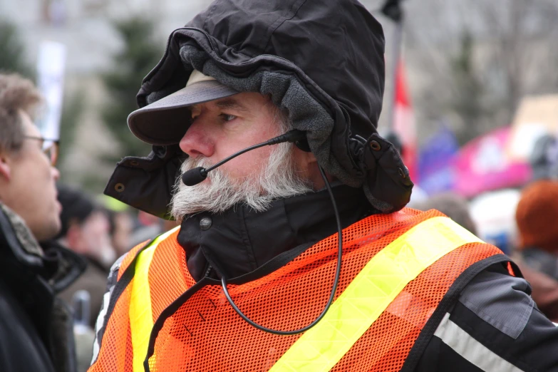 a man with a beard wearing a safety vest and head phones