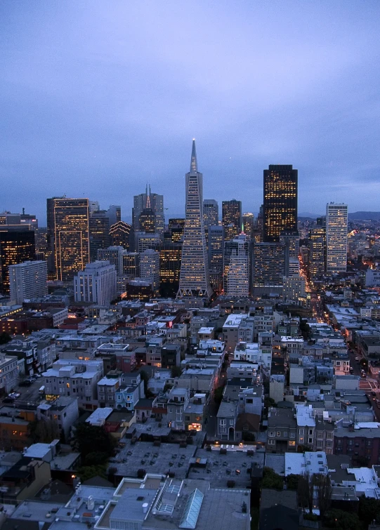 the city skyline is lit up by a twilight