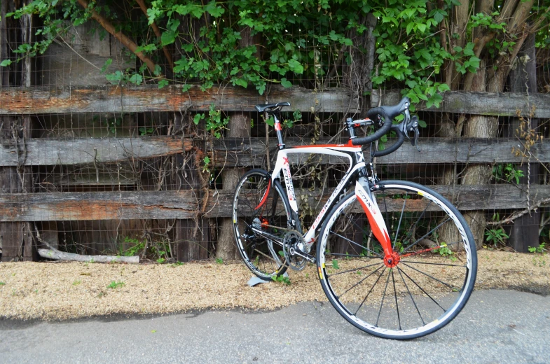 a bike is leaning against a wooden fence