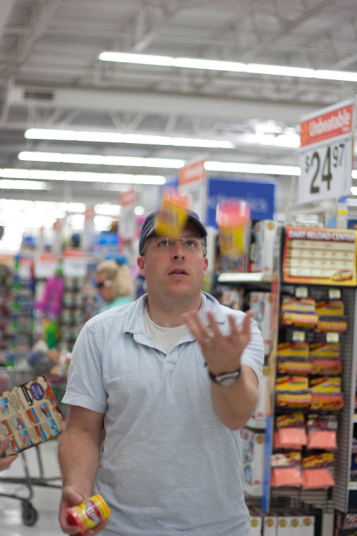 a man in a grocery store holding his hand out