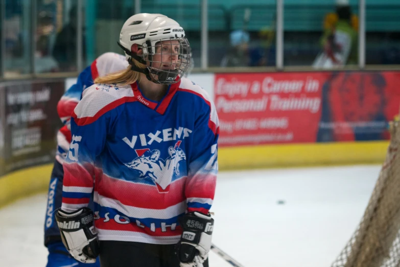 a hockey player standing by the net with his arm wrapped