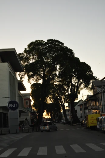the sun sets on an urban street in a residential area