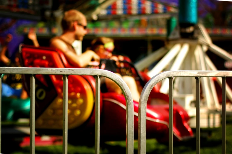 a little boy rides a red bumper car at the carnival
