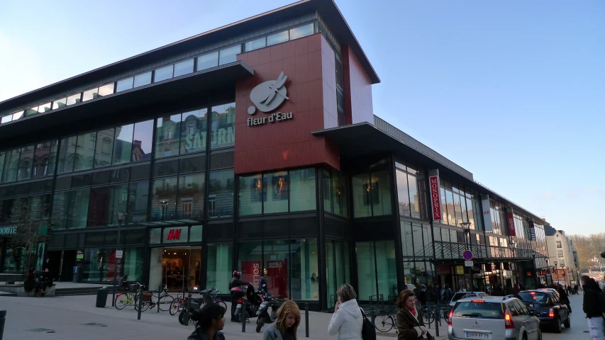 people are walking by and on the sidewalk in front of a shopping center