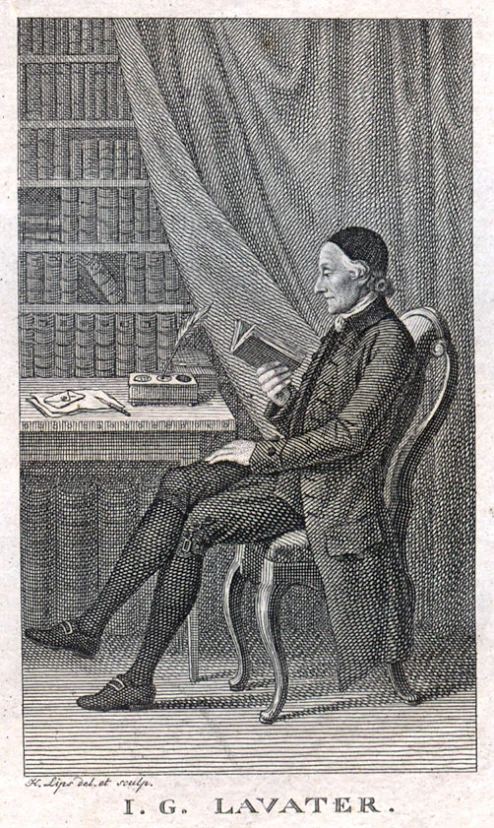 a man sitting in front of a book shelf