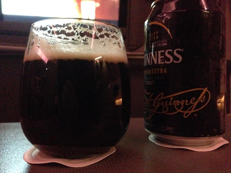 a bottle of guinness sits next to a glass filled with beer