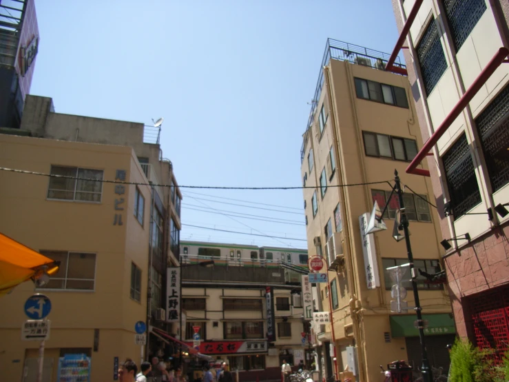 a crowded city street with various buildings and people walking on it