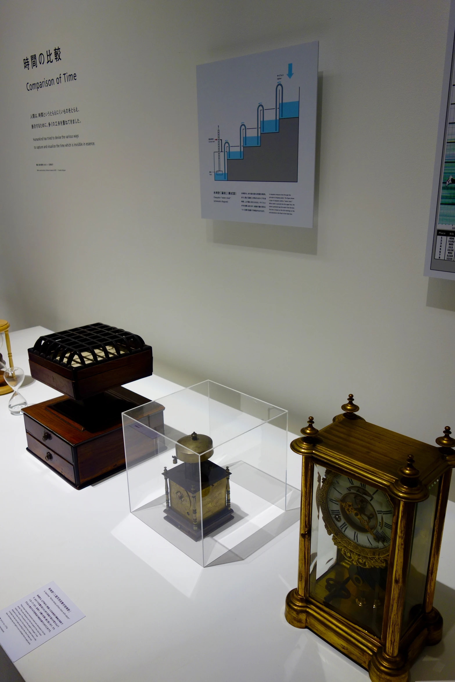 an old clock sitting on display with other different models