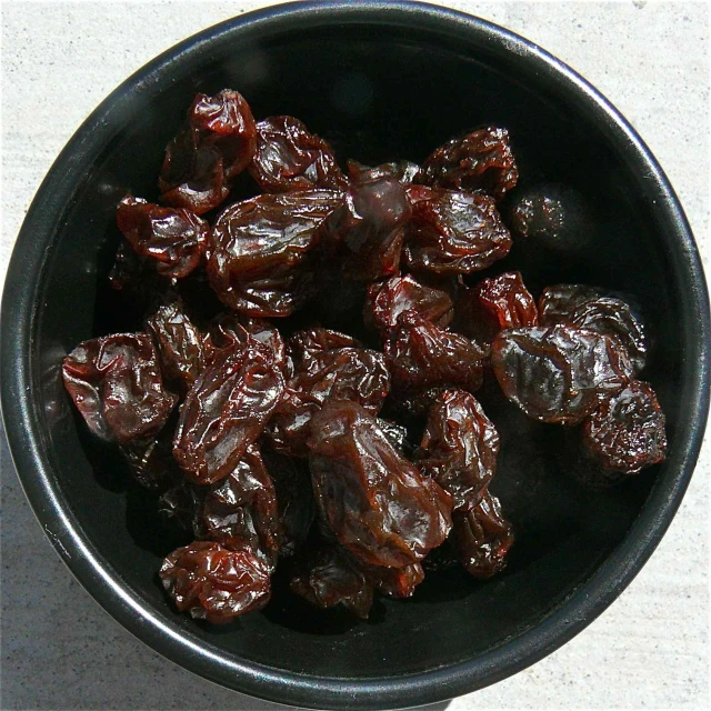 a bowl of raisins is sitting on the counter