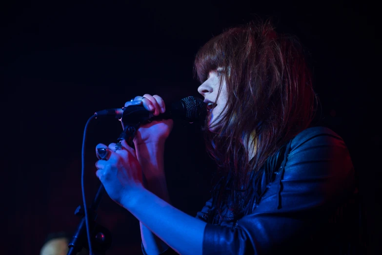 a woman standing with a microphone in front of her