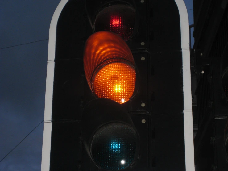 a red and green traffic light hanging off the side of a pole