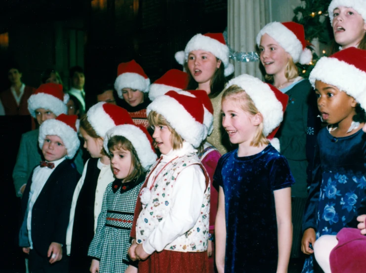 a group of young children are singing together