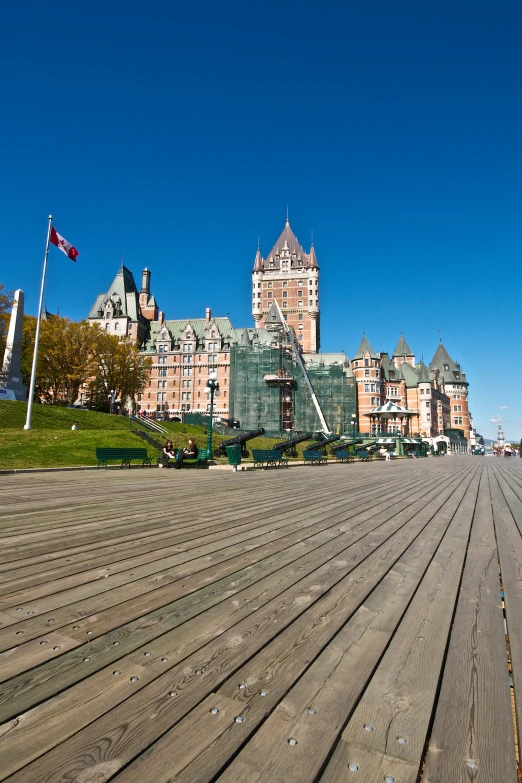 a wooden walkway next to a large building