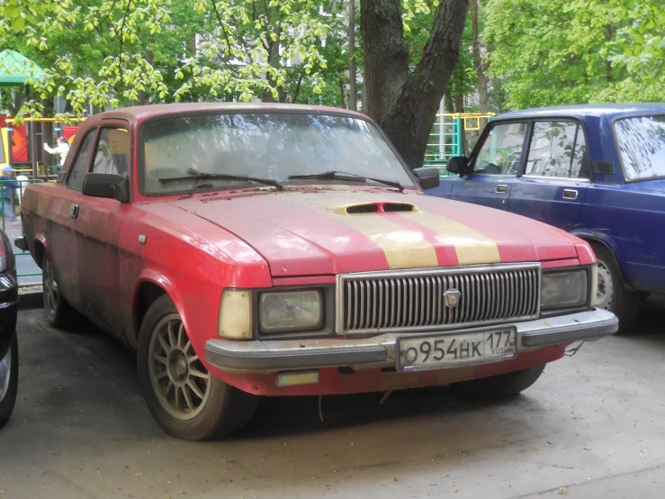 this old red car has gold and black stripes