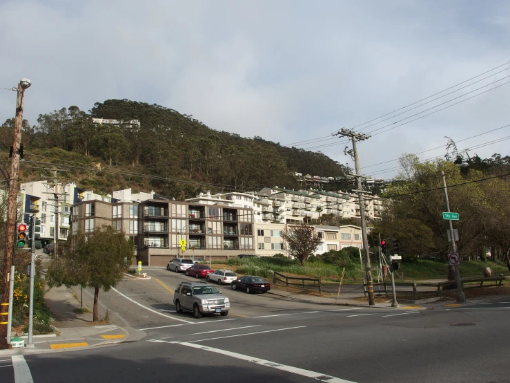 cars driving down a street with a lot of trees