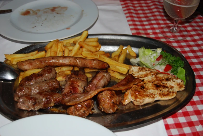a plate with fries, meat and other food on it