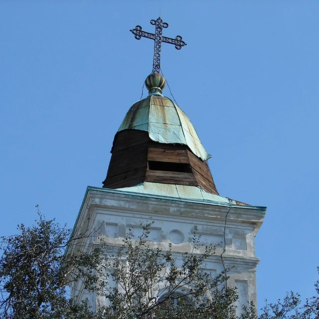 an old clock tower with a cross on top