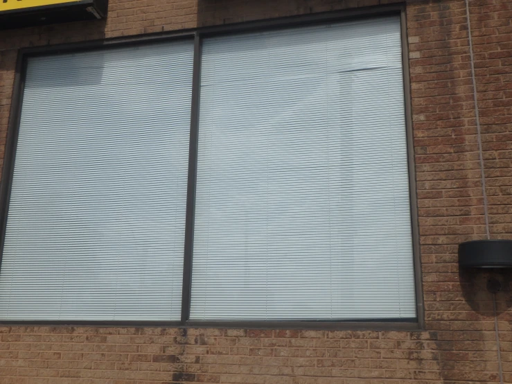 an exterior of a brick building with blinds closed