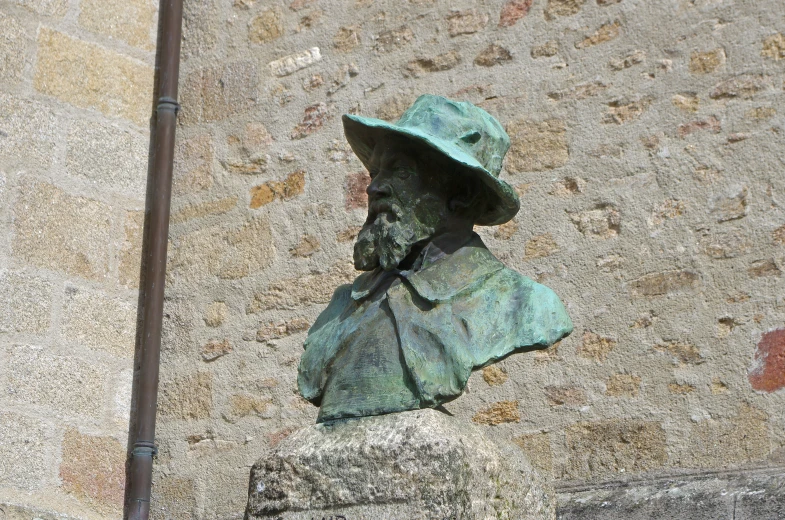 a bronze statue of a person with a hat on