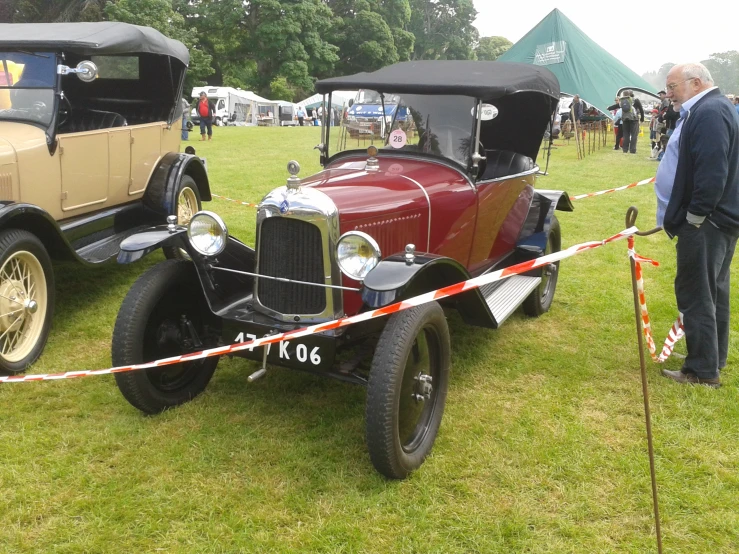 an old time car is parked on the grass