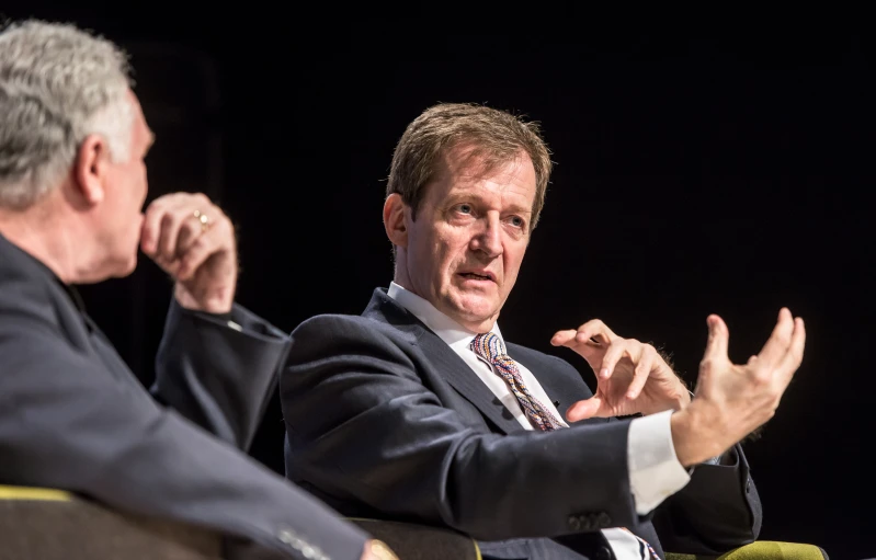 two men sitting at a table during a seminar