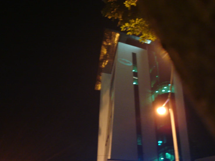 the large tower is illuminated in green at night