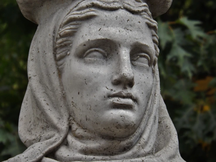 there is a statue with a woman's head and hood