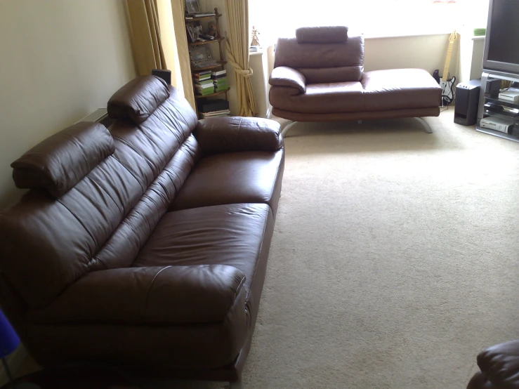 a tan leather couch and chair in a large room