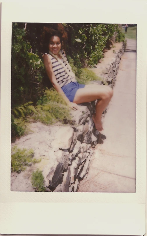 an old black woman standing next to some rocks