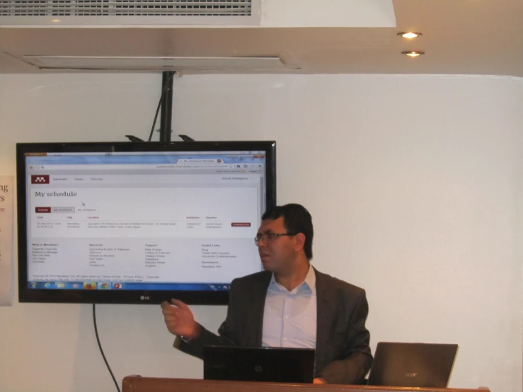 a man presenting a presentation on a wide screen