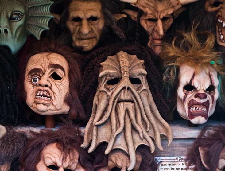 a display of scary masks with hair in various colors