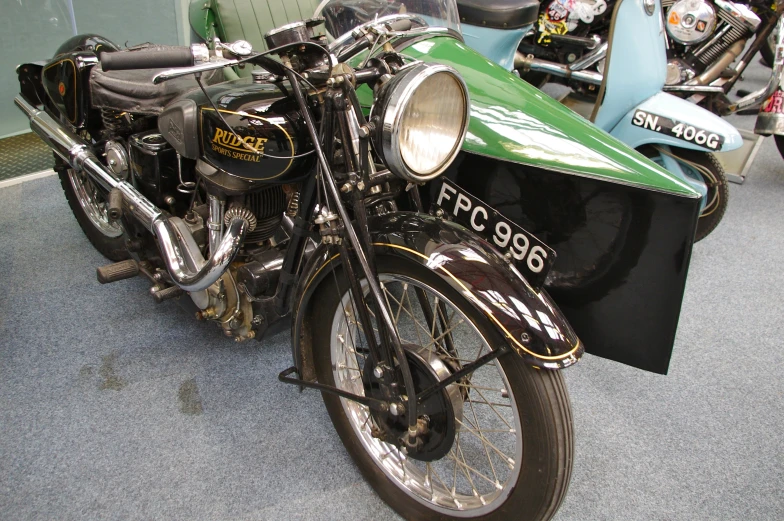 a green motorcycle sitting next to a motorcycle stand