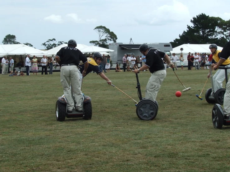 four guys on golf carts in the grass