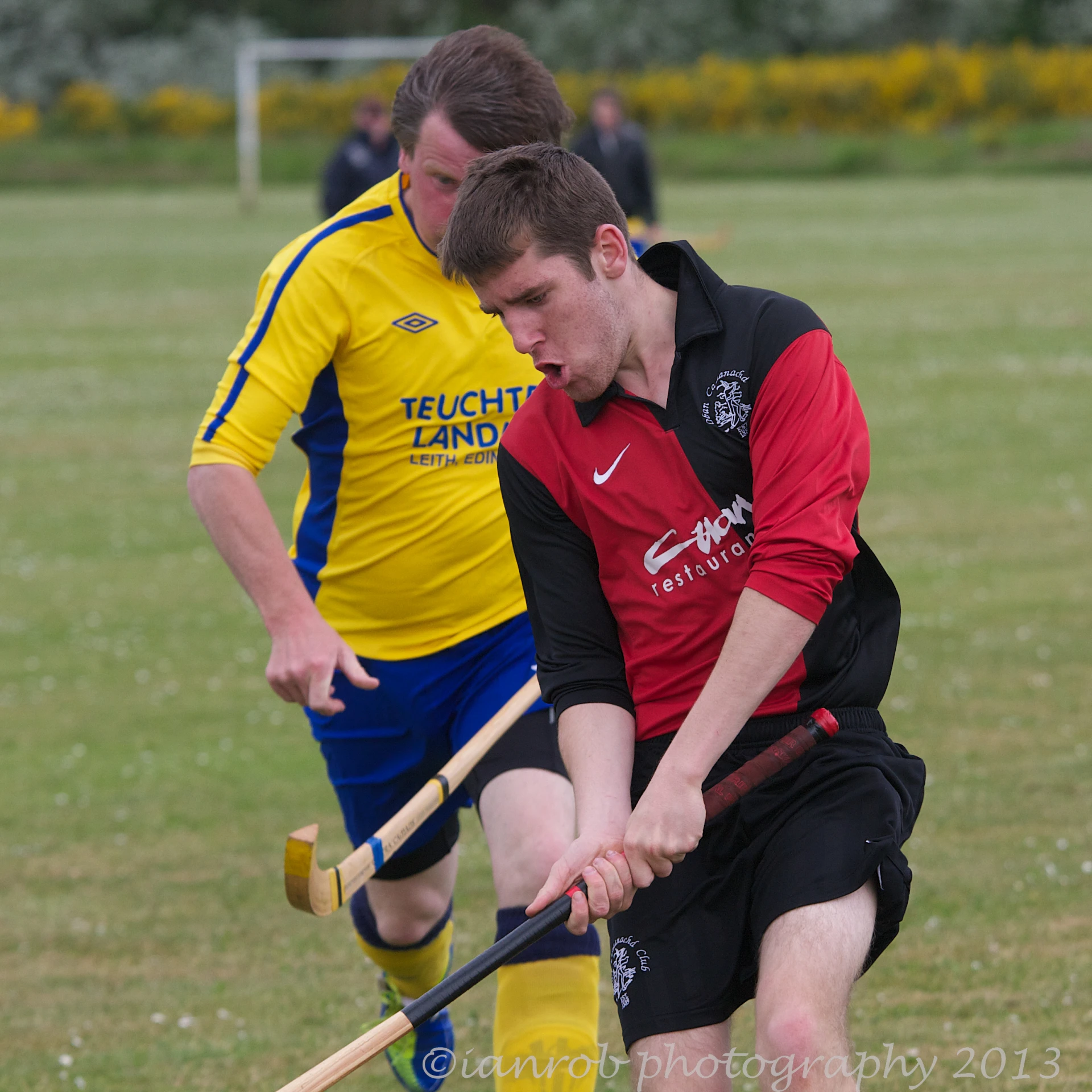 two men playing soccer with sticks and gloves