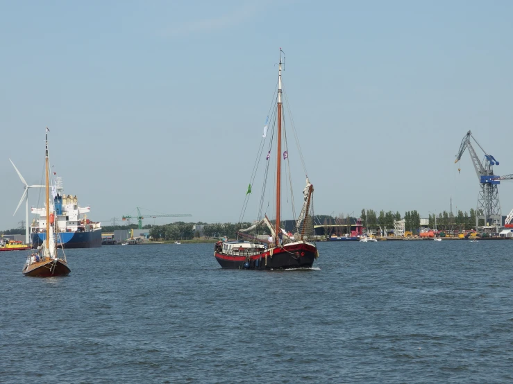 three boats floating on top of a large body of water