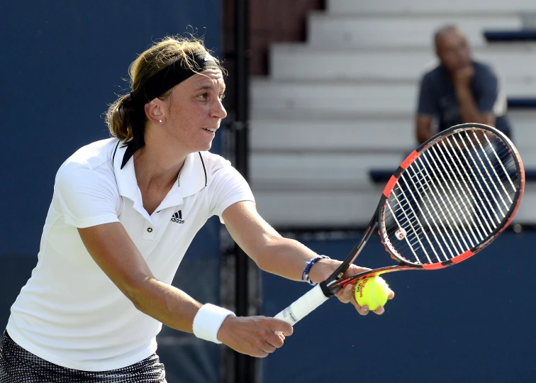 a woman swings a tennis racket at a ball